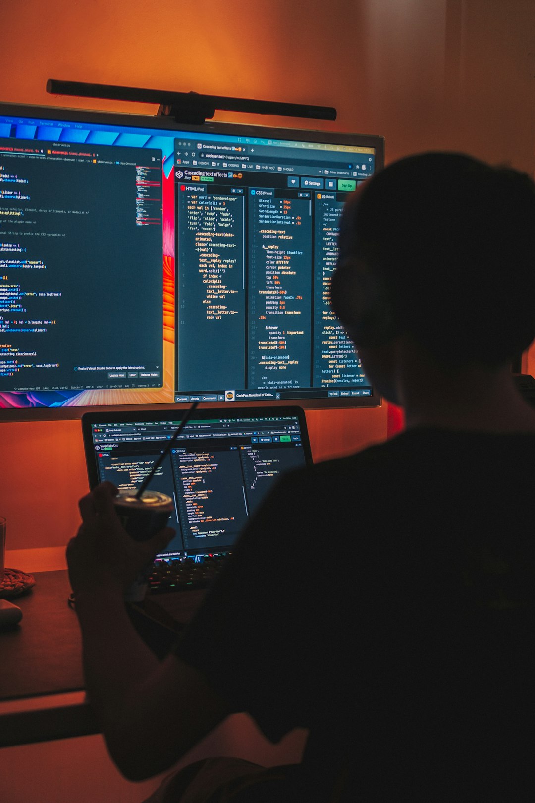 a-man-sitting-in-front-of-two-computer-monitors-kpgj50pwag0